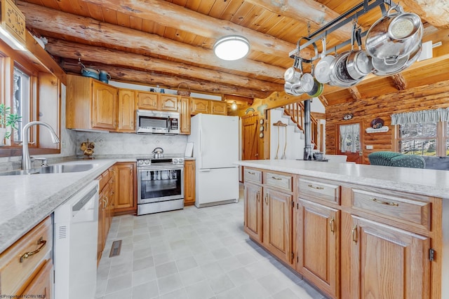 kitchen featuring a sink, stainless steel appliances, beamed ceiling, and wooden ceiling