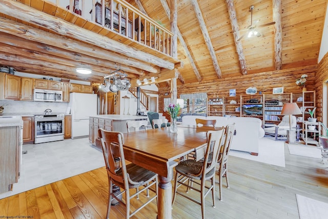 dining space with stairway, light wood finished floors, high vaulted ceiling, wooden ceiling, and beamed ceiling