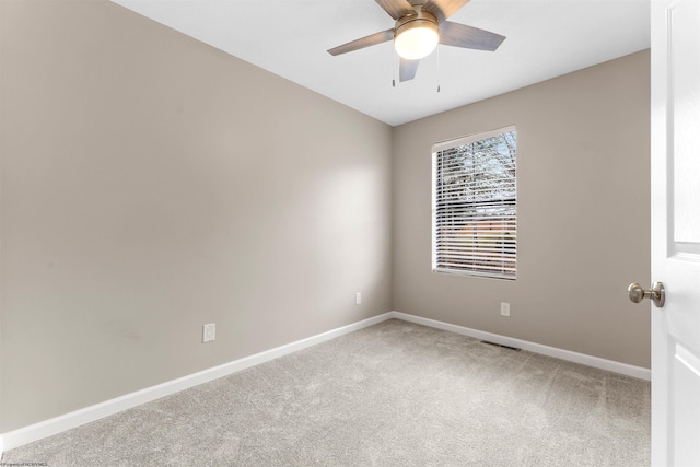 carpeted spare room with baseboards and a ceiling fan