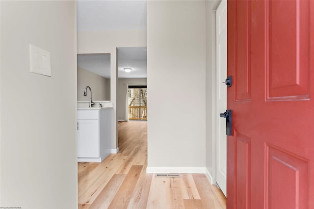 foyer with visible vents, baseboards, and light wood-style floors