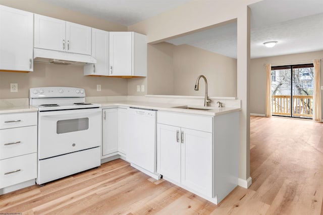 kitchen with white appliances, a sink, light countertops, light wood-style floors, and under cabinet range hood