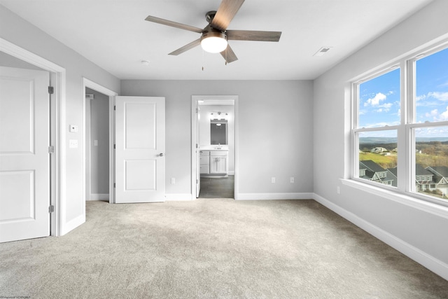 unfurnished bedroom featuring baseboards, visible vents, ceiling fan, ensuite bathroom, and carpet flooring