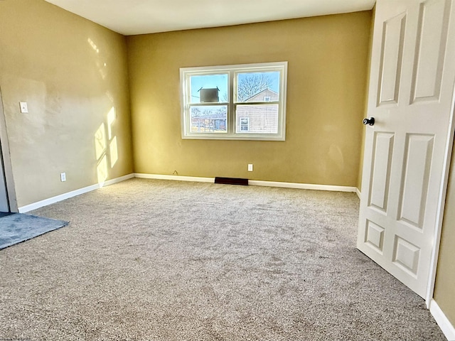 spare room featuring baseboards and carpet flooring