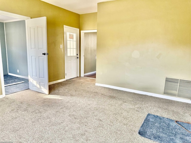 carpeted spare room featuring visible vents and baseboards