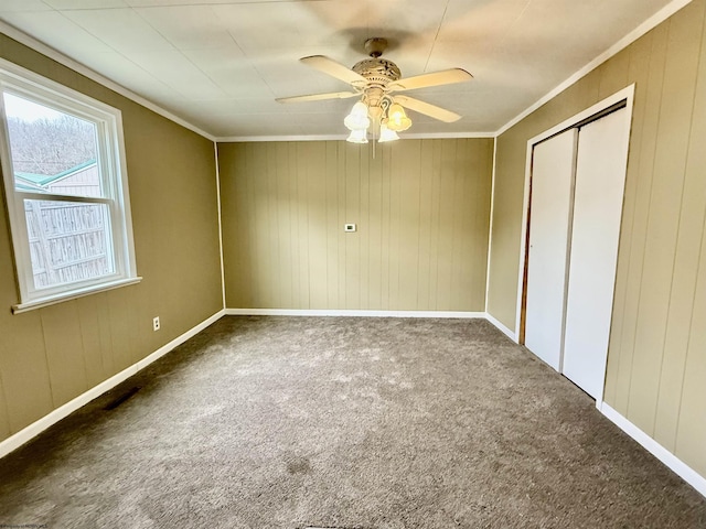 unfurnished bedroom with visible vents, crown molding, carpet flooring, a closet, and a ceiling fan