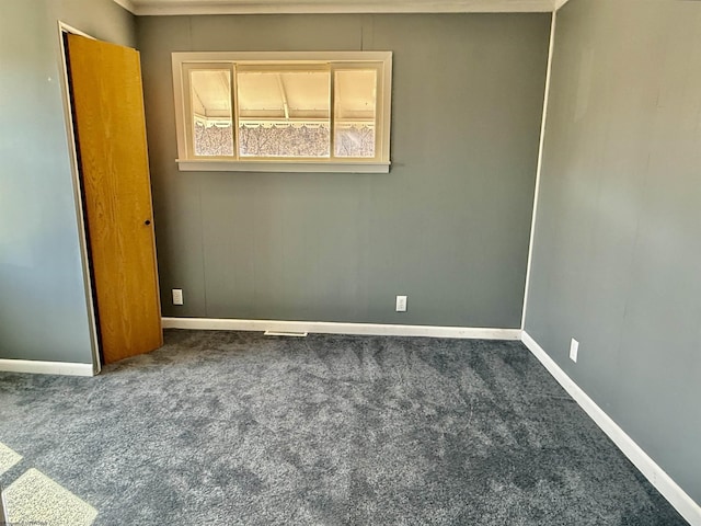 spare room featuring baseboards and carpet flooring