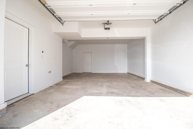 garage featuring a garage door opener and baseboards