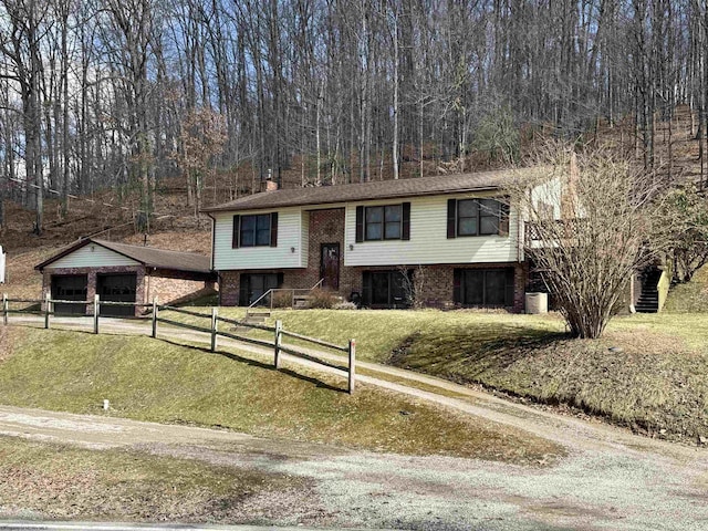 bi-level home featuring brick siding, a chimney, a front lawn, and fence