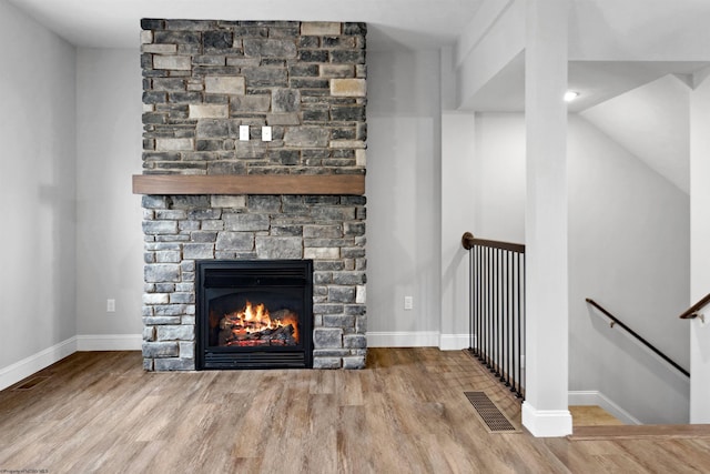 room details with visible vents, baseboards, wood finished floors, and a fireplace