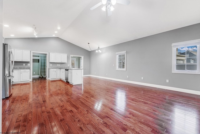 unfurnished living room with baseboards, high vaulted ceiling, recessed lighting, ceiling fan, and wood-type flooring