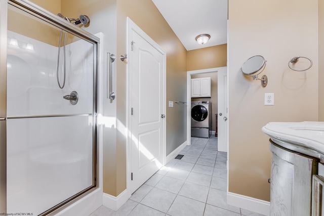 bathroom with tile patterned floors, baseboards, washer / clothes dryer, and a stall shower