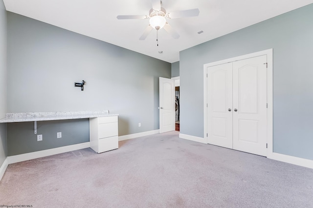 unfurnished bedroom with baseboards, light carpet, a closet, and a ceiling fan