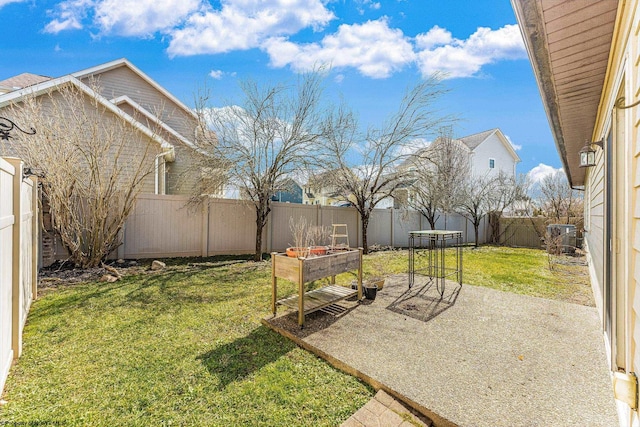 view of yard featuring a patio, a fenced backyard, and a garden