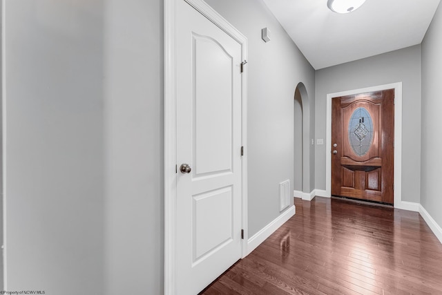 entrance foyer featuring visible vents, wood-type flooring, arched walkways, and baseboards