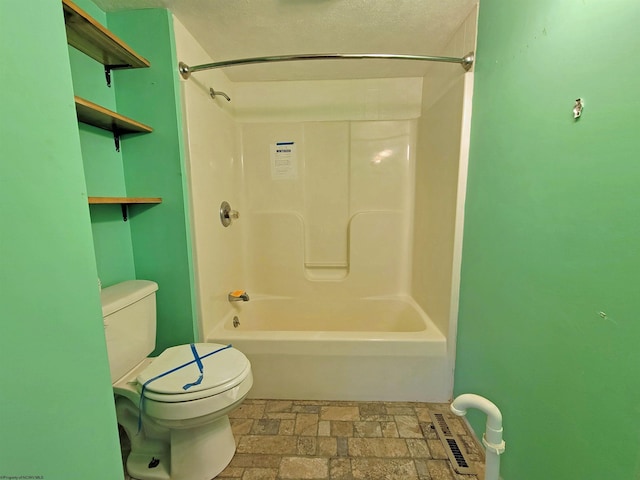 bathroom featuring visible vents, stone finish floor, a textured ceiling, bathing tub / shower combination, and toilet