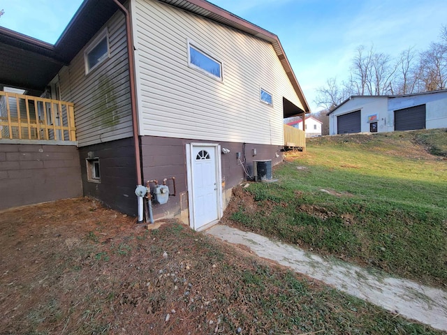 view of side of property featuring central air condition unit and a yard