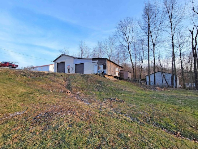 view of yard featuring a garage and an outdoor structure