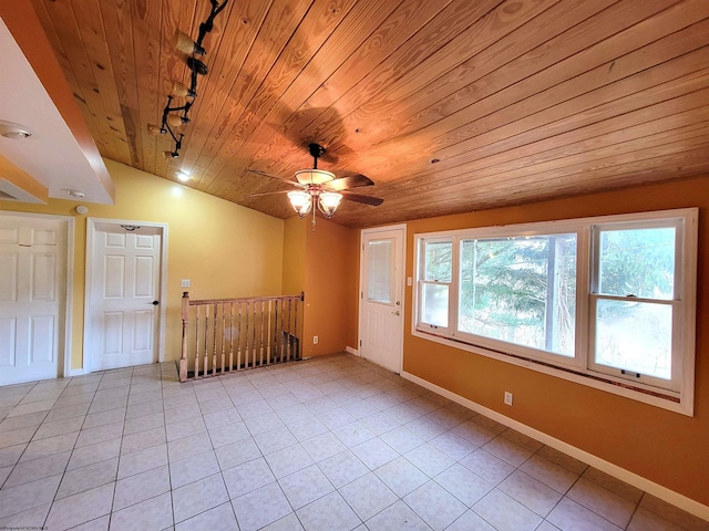 empty room with light tile patterned floors, wood ceiling, a ceiling fan, and vaulted ceiling