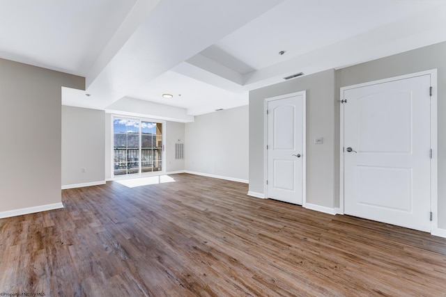 spare room featuring visible vents, baseboards, and wood finished floors