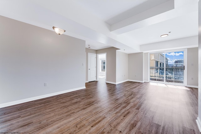 unfurnished room with baseboards and dark wood-type flooring