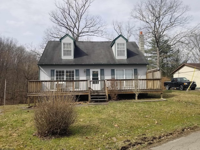 cape cod home with a chimney, a deck, and a front lawn