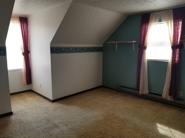 bonus room featuring a baseboard heating unit, baseboards, lofted ceiling, carpet floors, and a textured ceiling