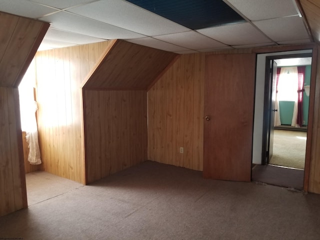 additional living space featuring wooden walls and carpet