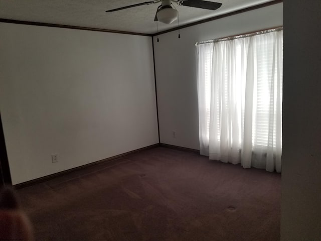 carpeted spare room featuring a textured ceiling, a ceiling fan, baseboards, and ornamental molding