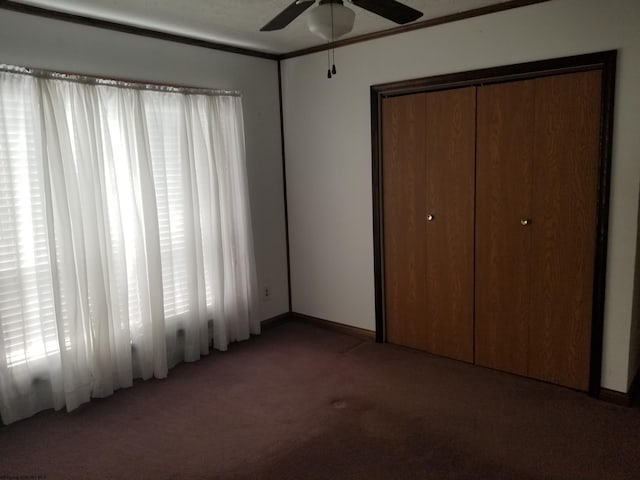 unfurnished bedroom with a closet, baseboards, a ceiling fan, and carpet