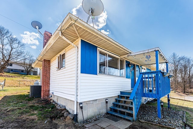 view of side of property featuring cooling unit and a chimney