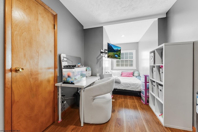 bedroom featuring a textured ceiling and wood finished floors