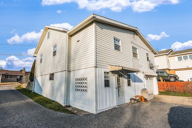 back of house featuring aphalt driveway and a garage