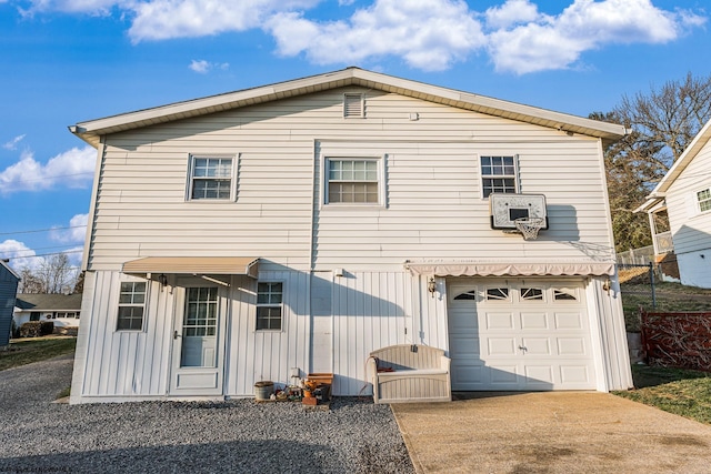 back of property featuring a garage, board and batten siding, and driveway