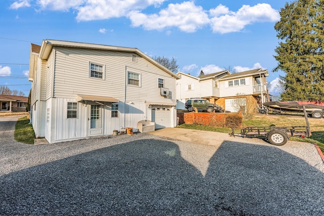 back of house featuring gravel driveway and a garage