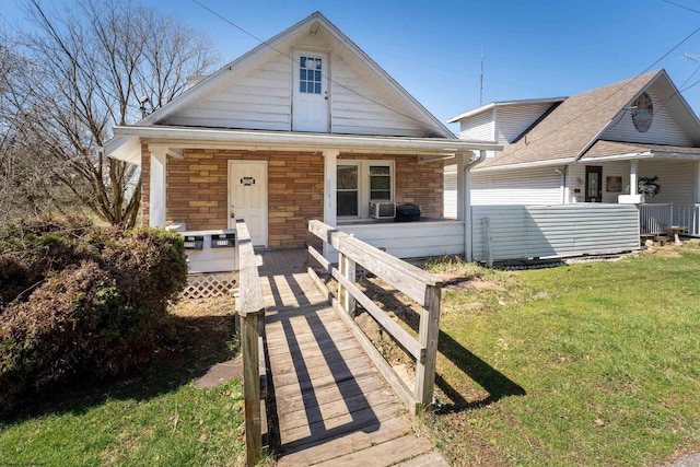 view of front facade with stone siding, covered porch, and a front lawn