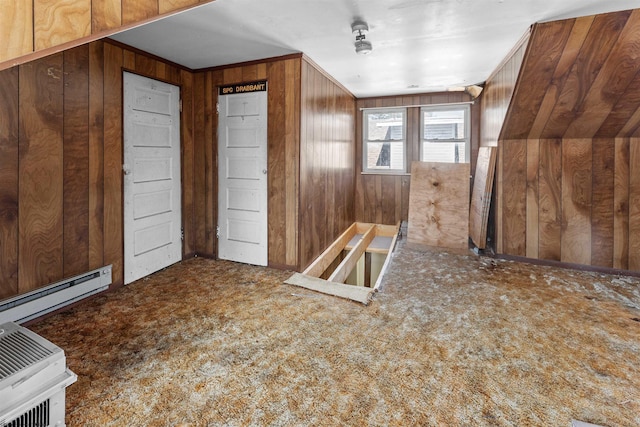 bonus room with wooden walls and a baseboard radiator