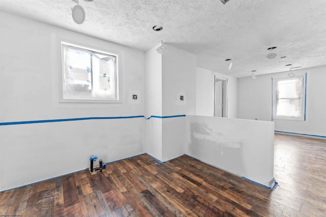 unfurnished room with wood-type flooring and a textured ceiling