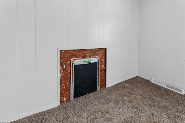 unfurnished living room with carpet floors, a fireplace, and visible vents