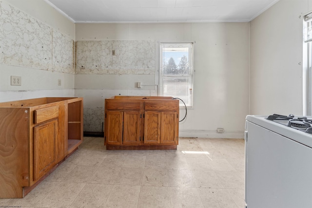 kitchen with light countertops, brown cabinets, stove, and ornamental molding