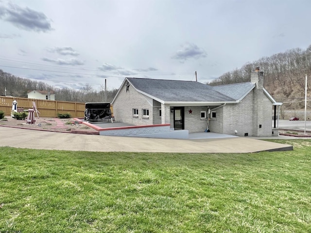 762 Pearl St, Grafton, WV 26354 - back of house with fence, a chimney, brick siding, a lawn, and a patio area