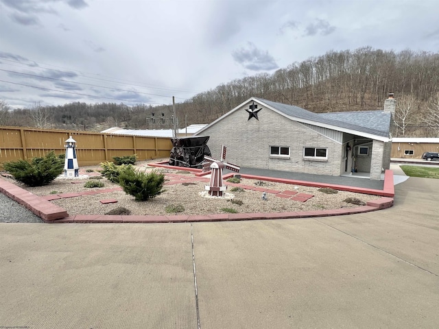 762 Pearl St, Grafton, WV 26354 - view of home's exterior with roof with shingles, fence, and a chimney