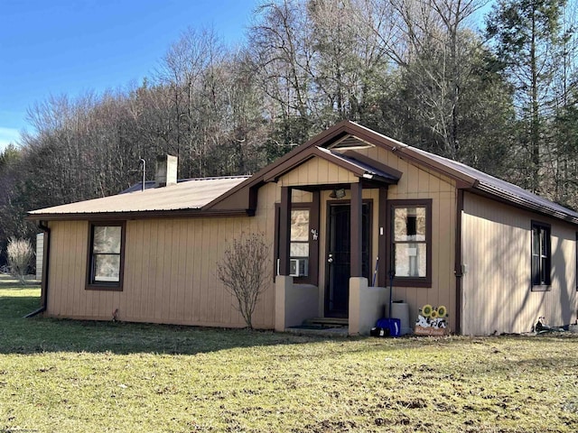 view of front of house with metal roof and a front yard