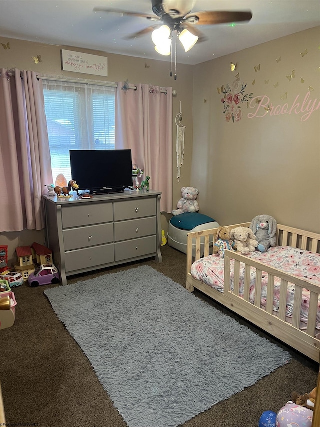 carpeted bedroom featuring a crib and ceiling fan