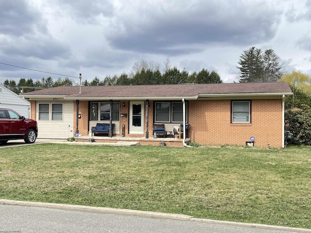 ranch-style home featuring brick siding, a porch, and a front yard