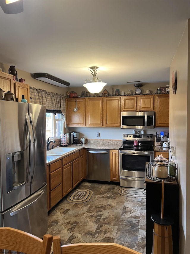 kitchen with brown cabinets, light countertops, a sink, and stainless steel appliances