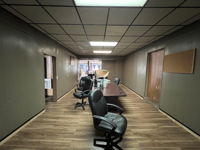 home office with a drop ceiling and wood finished floors
