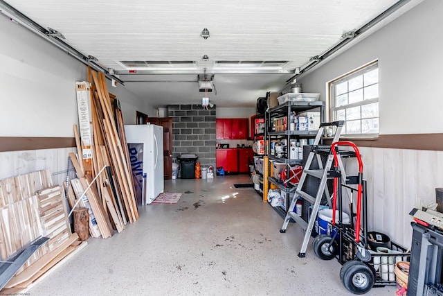 garage featuring freestanding refrigerator and a garage door opener