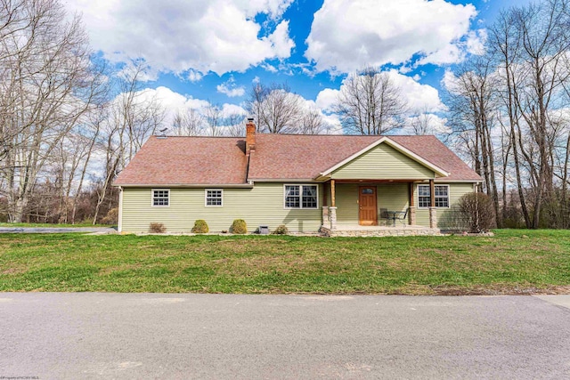 ranch-style home with a front lawn, a chimney, a shingled roof, and covered porch
