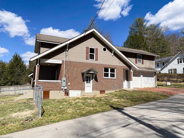 view of front of home with fence, driveway, a front yard, brick siding, and a garage