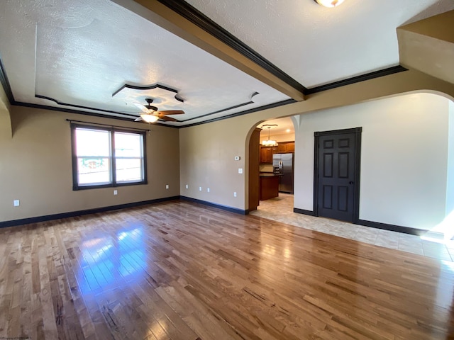 unfurnished room featuring arched walkways, ceiling fan, and a textured ceiling